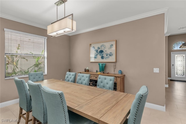 dining room with light tile patterned floors, ornamental molding, and baseboards