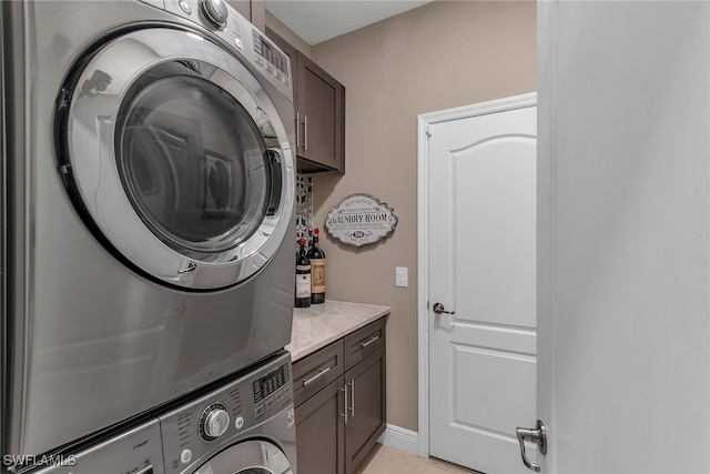 laundry area featuring cabinet space and stacked washing maching and dryer