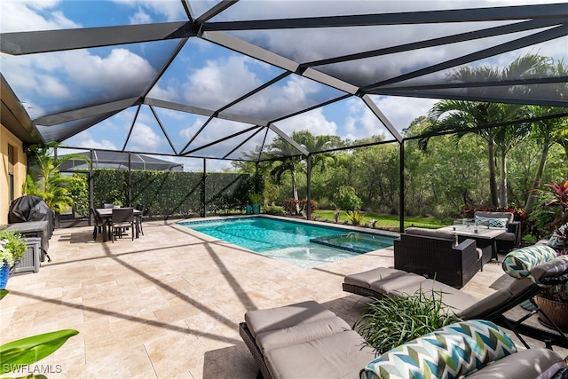 view of pool featuring a lanai, outdoor dining area, a patio area, a pool with connected hot tub, and an outdoor living space