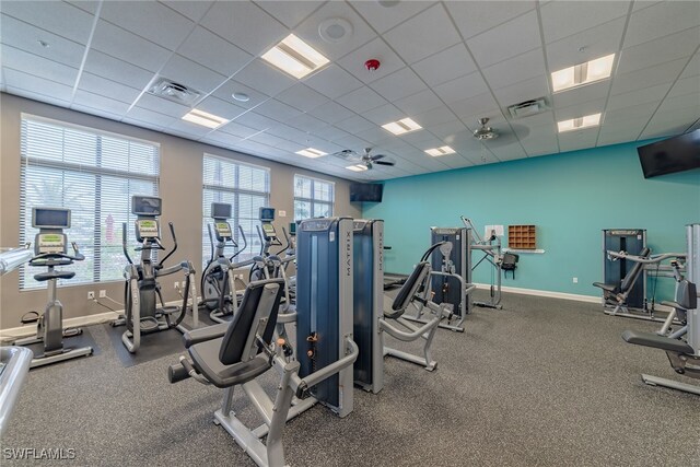 workout area featuring a drop ceiling, visible vents, and baseboards