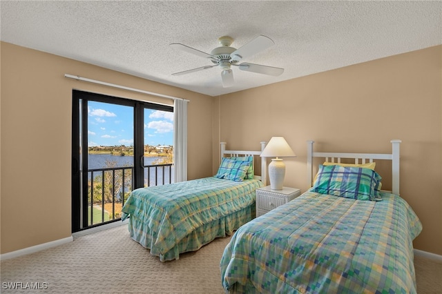 carpeted bedroom featuring baseboards, ceiling fan, a water view, access to exterior, and a textured ceiling