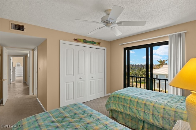 carpeted bedroom featuring access to exterior, a closet, visible vents, a ceiling fan, and a textured ceiling