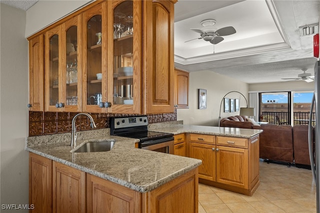 kitchen with open floor plan, a peninsula, light stone countertops, stainless steel range with electric stovetop, and a sink