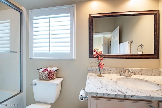 bathroom featuring a shower with door, vanity, and toilet