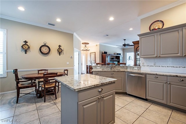 kitchen with visible vents, dishwasher, a kitchen island, gray cabinets, and a sink