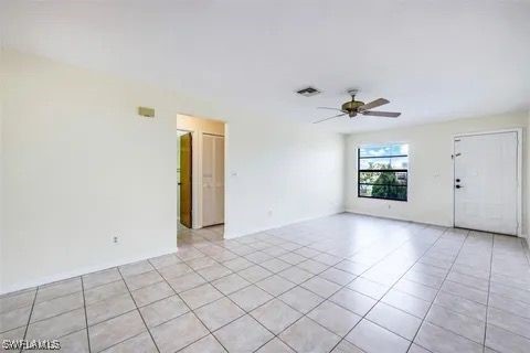 spare room featuring ceiling fan, visible vents, and light tile patterned flooring