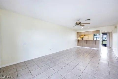 unfurnished living room featuring light tile patterned floors, ceiling fan, and visible vents