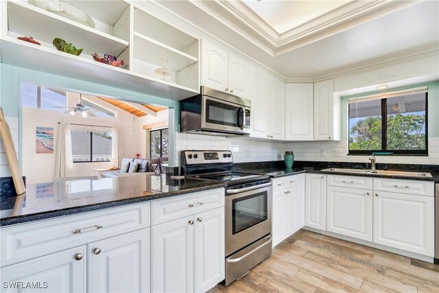 kitchen featuring crown molding, light wood finished floors, open shelves, stainless steel appliances, and tasteful backsplash