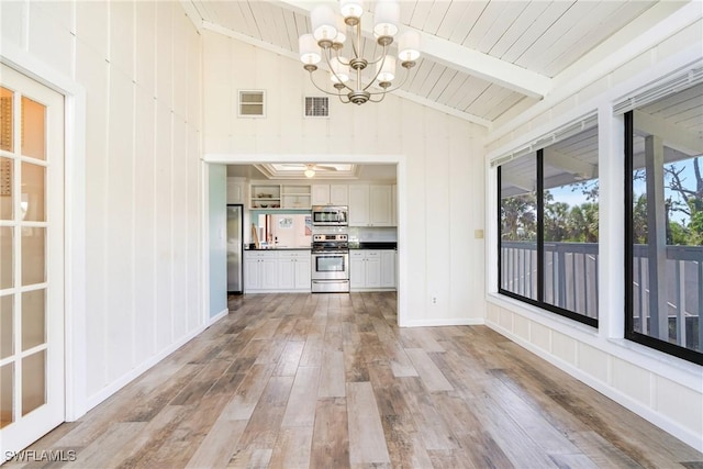 interior space with vaulted ceiling with beams, light wood finished floors, visible vents, and a chandelier