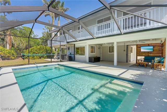 outdoor pool with a ceiling fan, a lanai, a patio, and an outdoor living space