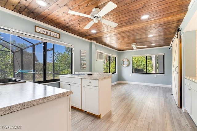 kitchen with wood ceiling, light countertops, light wood-style flooring, and a barn door