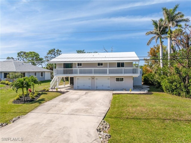 view of front of home with stairs, concrete driveway, a front lawn, and covered porch