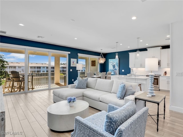 living room featuring light wood finished floors, visible vents, and recessed lighting