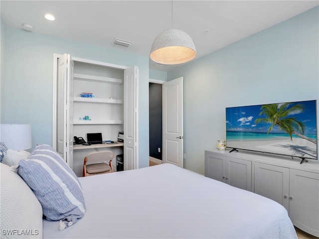 bedroom featuring visible vents, built in desk, and recessed lighting