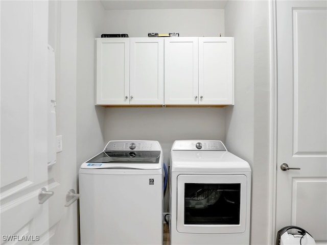 clothes washing area with cabinet space and washer and clothes dryer