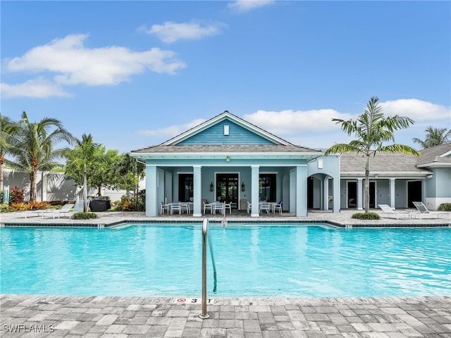 community pool with a patio area and fence