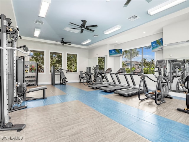 exercise room featuring ceiling fan, visible vents, and baseboards