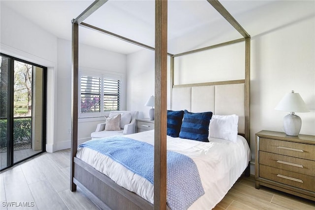 bedroom featuring wood tiled floor and access to outside