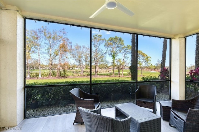 sunroom / solarium featuring a ceiling fan