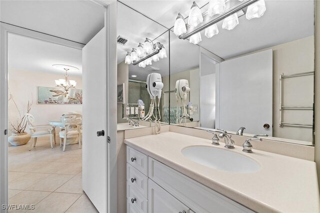 bathroom with a chandelier, visible vents, vanity, and tile patterned floors