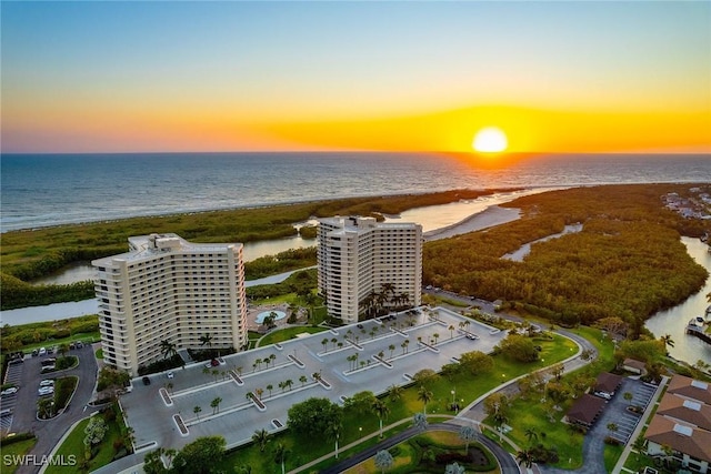 aerial view at dusk featuring a water view