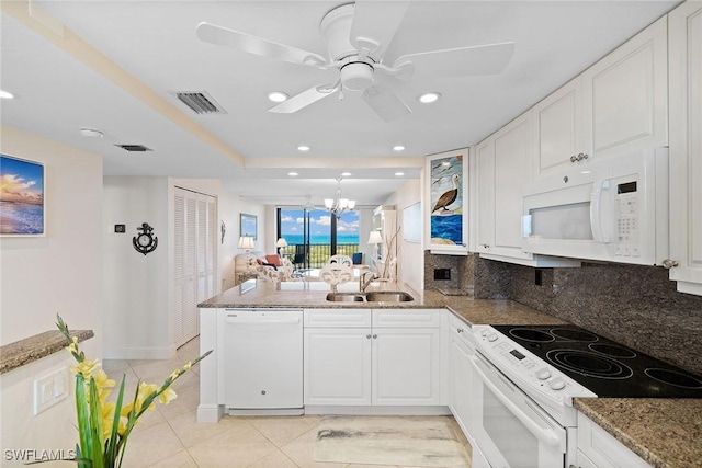 kitchen with white appliances, tasteful backsplash, visible vents, and a sink