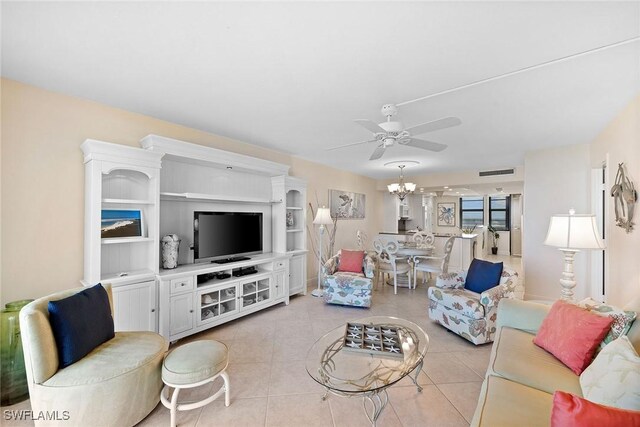 living room featuring light tile patterned floors, ceiling fan with notable chandelier, and visible vents