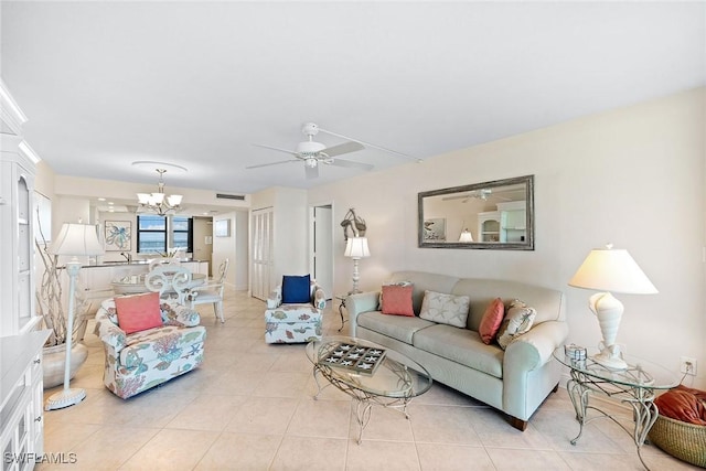 living area featuring light tile patterned flooring, visible vents, and ceiling fan with notable chandelier