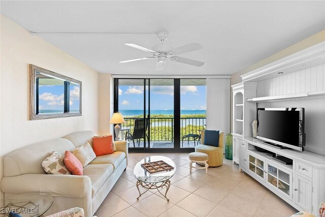 living area with floor to ceiling windows, ceiling fan, and light tile patterned floors