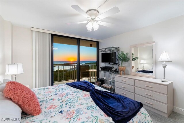 carpeted bedroom featuring access to exterior, expansive windows, and a ceiling fan