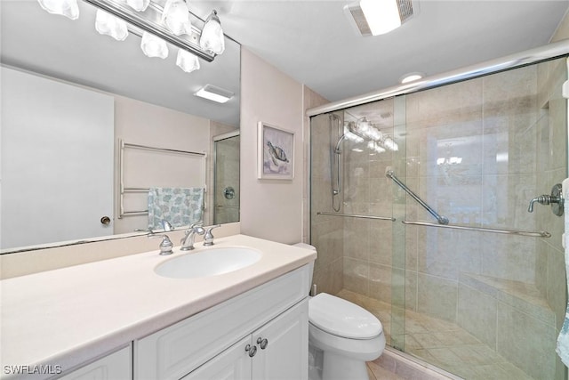 bathroom featuring toilet, a shower stall, visible vents, and vanity