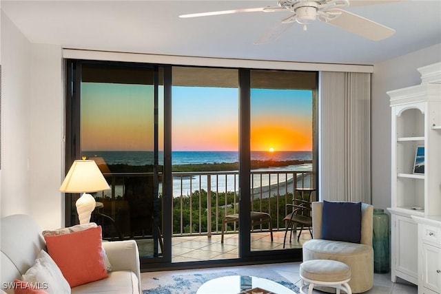 interior space featuring light tile patterned floors, ceiling fan, a water view, and floor to ceiling windows