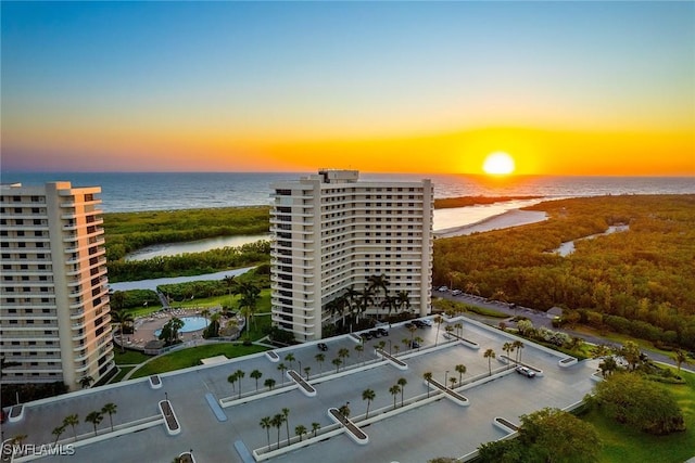 aerial view at dusk featuring a water view