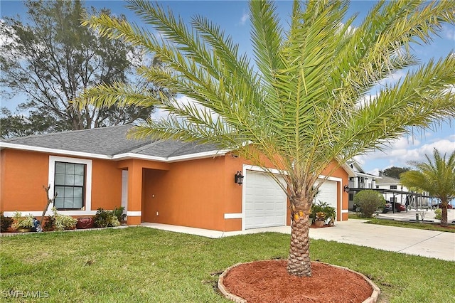 ranch-style home featuring a garage, concrete driveway, a front yard, and stucco siding