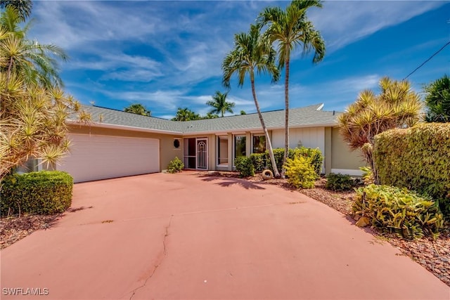 single story home featuring concrete driveway and an attached garage