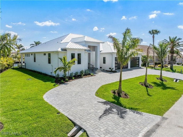 view of front of property featuring a standing seam roof, a front lawn, metal roof, and curved driveway