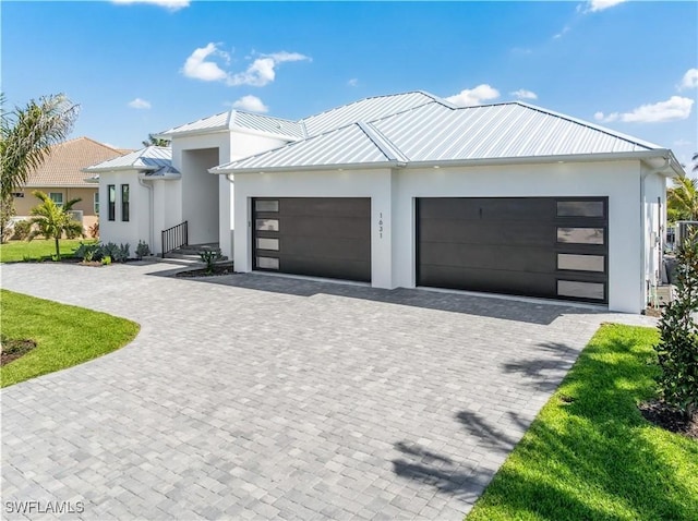 view of front of property featuring decorative driveway, a garage, and stucco siding