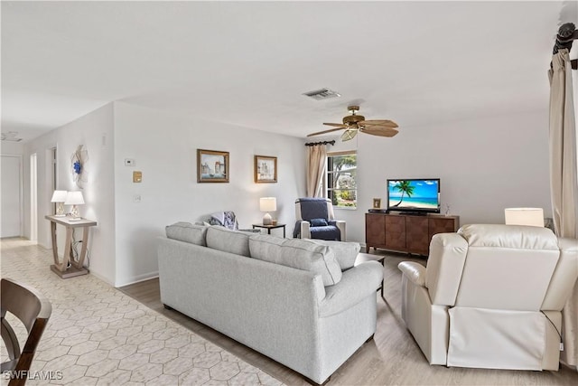 living area with baseboards, ceiling fan, visible vents, and wood finished floors