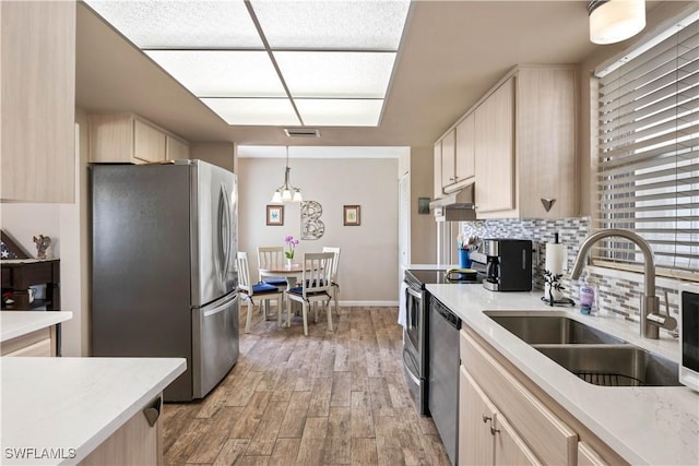 kitchen featuring light wood finished floors, visible vents, stainless steel appliances, light brown cabinets, and a sink