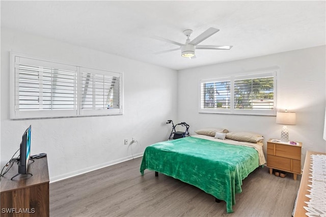 bedroom featuring ceiling fan, wood finished floors, and baseboards