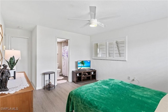 bedroom with ceiling fan, connected bathroom, and wood finished floors