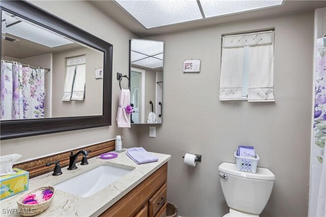 full bathroom with visible vents, vanity, and toilet