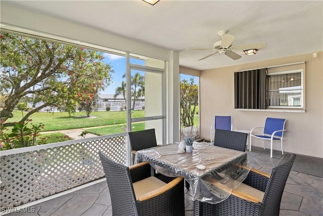 sunroom / solarium featuring a ceiling fan