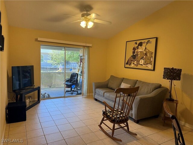 living area with light tile patterned flooring, vaulted ceiling, baseboards, and ceiling fan