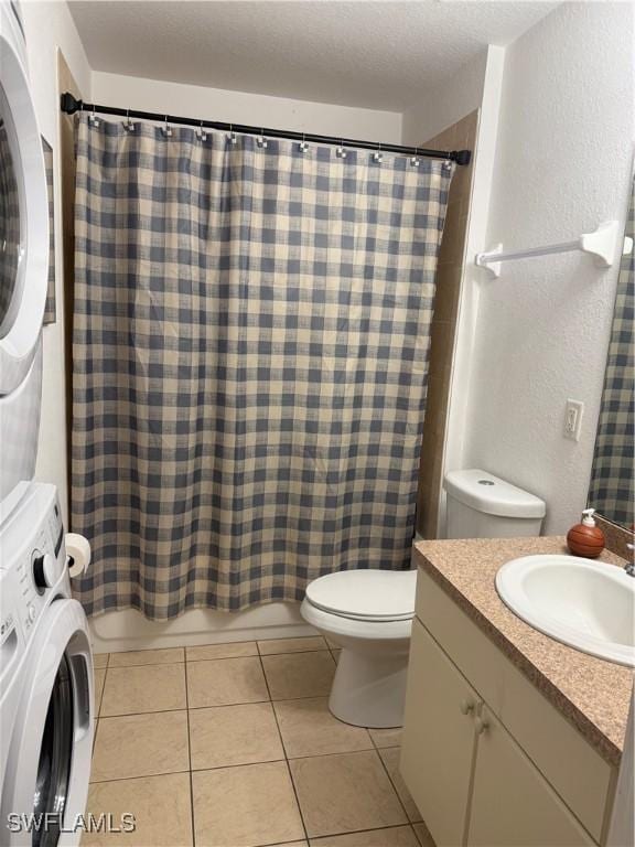 bathroom with stacked washer and dryer, toilet, a textured ceiling, vanity, and tile patterned flooring