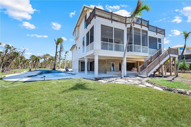 back of property with an outdoor pool, a patio, a sunroom, stairs, and a yard