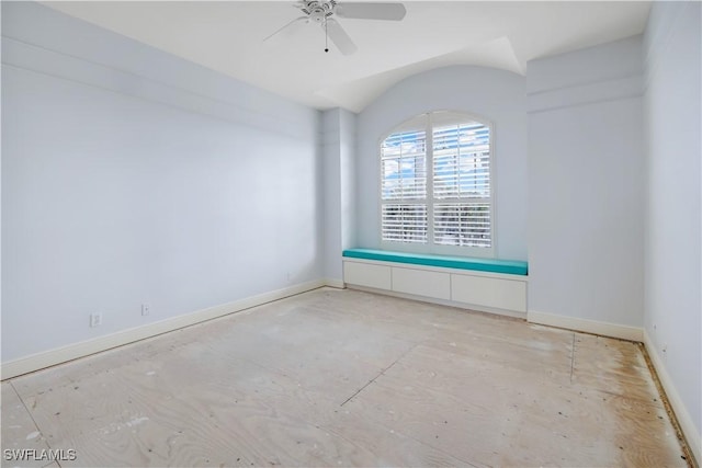 spare room with ceiling fan, baseboards, and vaulted ceiling