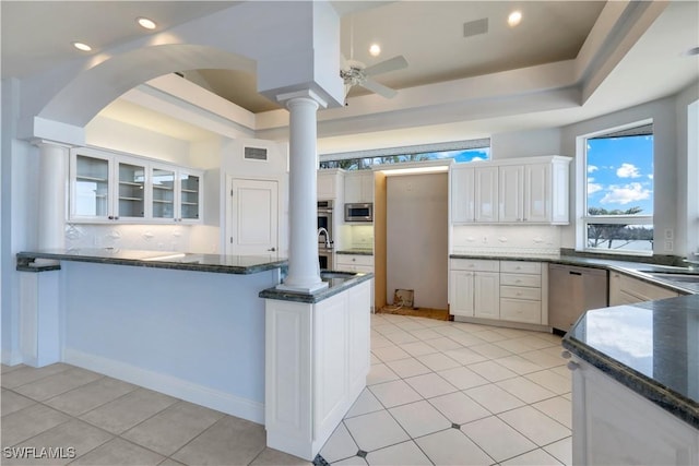 kitchen with stainless steel appliances, a peninsula, visible vents, white cabinets, and a tray ceiling