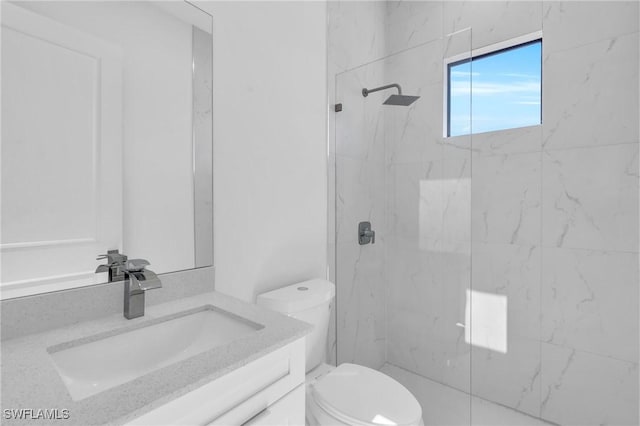 full bath with toilet, vanity, and a marble finish shower