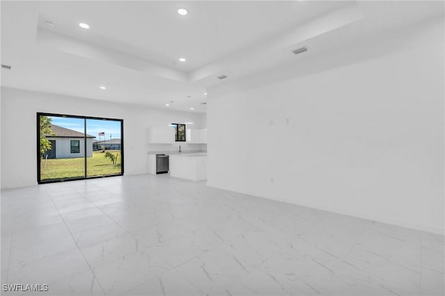 unfurnished living room featuring marble finish floor, visible vents, a tray ceiling, and recessed lighting